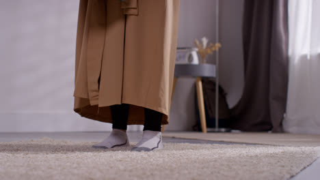 Nahaufnahme-Einer-Muslimischen-Frau-Zu-Hause,-Die-Ihre-Schuhe-Auszieht-Und-Eine-Gebetsmatte-Auf-Den-Boden-Legt